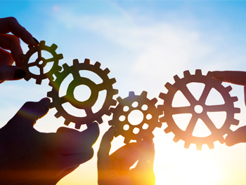 stock photo-four-hands-of-businessmen-collect-gear-from-the-gears-of-the-details-of-puzzles-against-the-1028168668